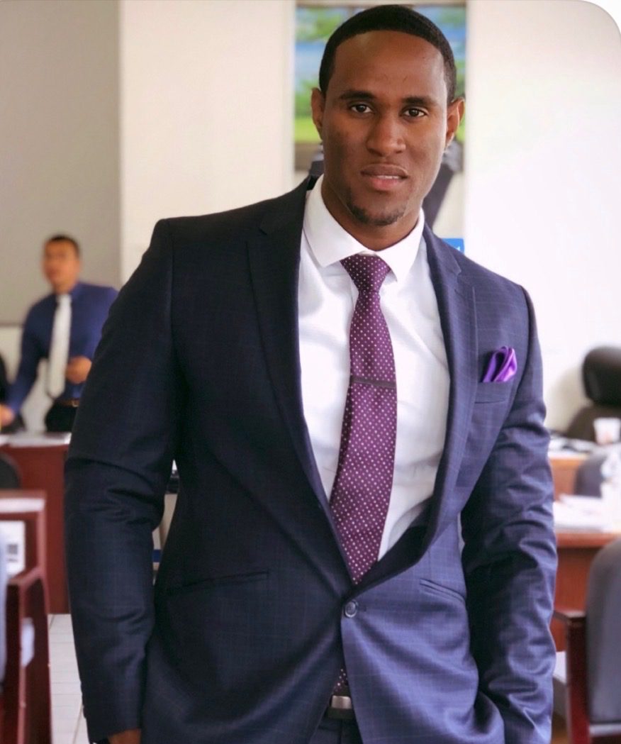 Founder of RIL Talk INC in a navy suit at a dealership